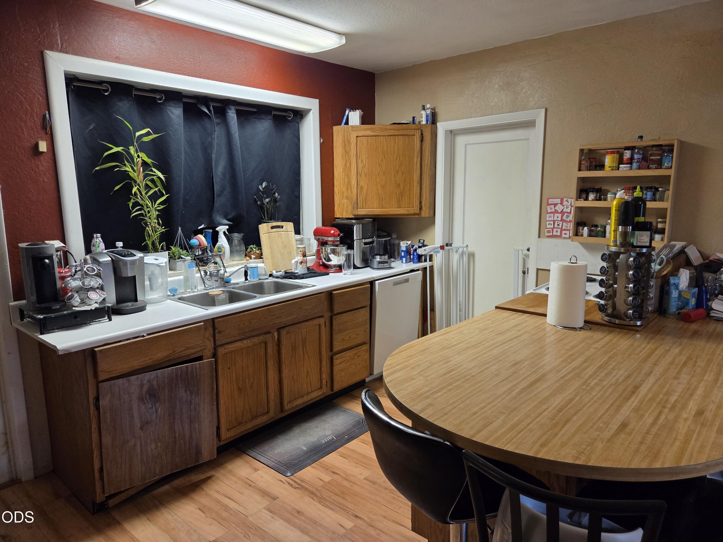 Kitchen with oak cabinets, a double sink, countertop appliances, and a large oval dining table.
