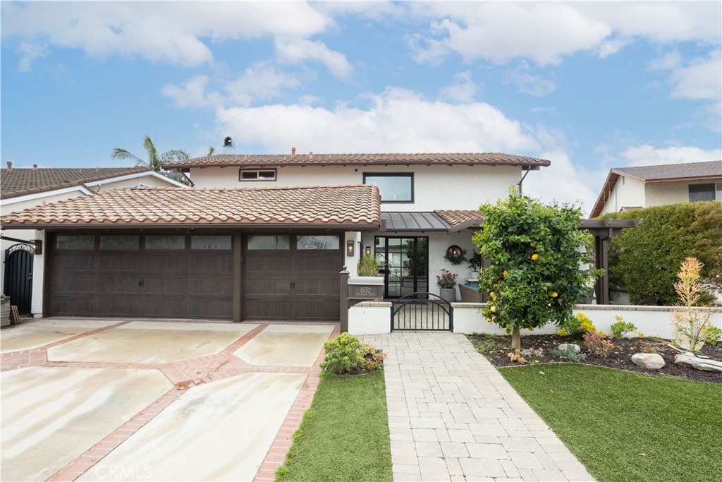 Two-story home with a broad double garage, tiled roof, and landscaped front walkway.