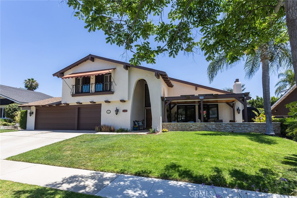 Two-story stucco home with an arched entry, double garage, and covered patio.