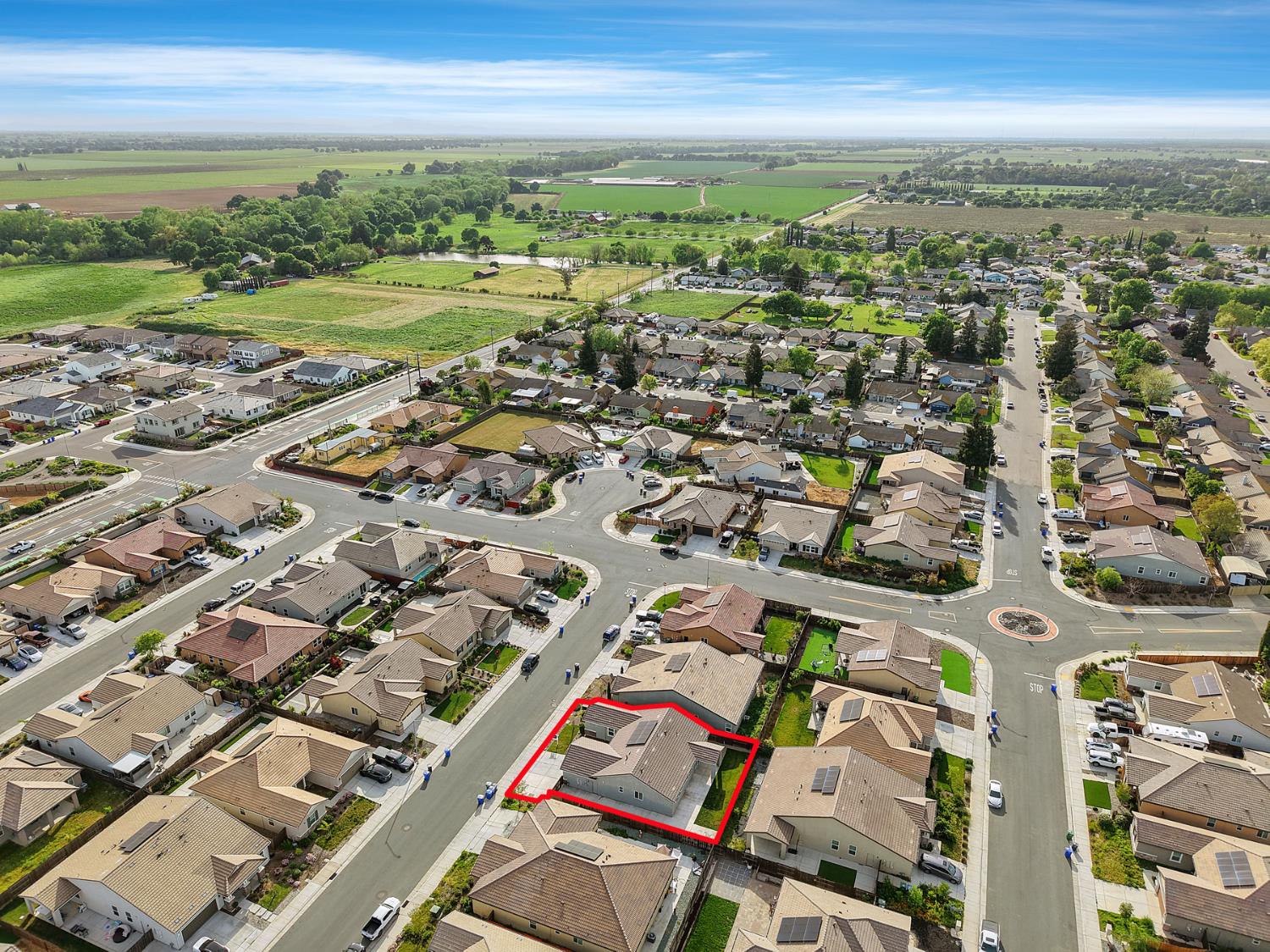 Aerial view of 691 Lippi Street, outlined in red among homes near open farmland.