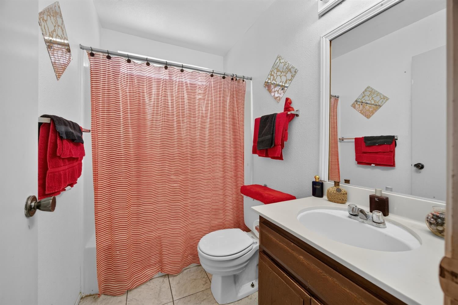 Bathroom with a dark wood vanity, white sink, and red-and-white striped shower curtain.