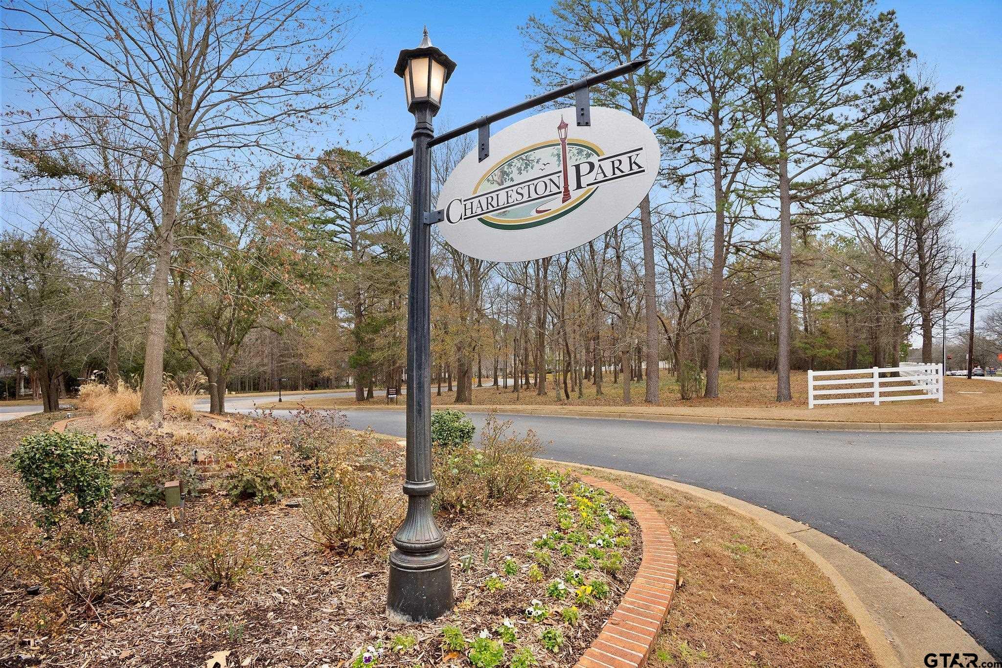 Charleston Park entrance sign beside a landscaped road and tree-lined neighborhood.