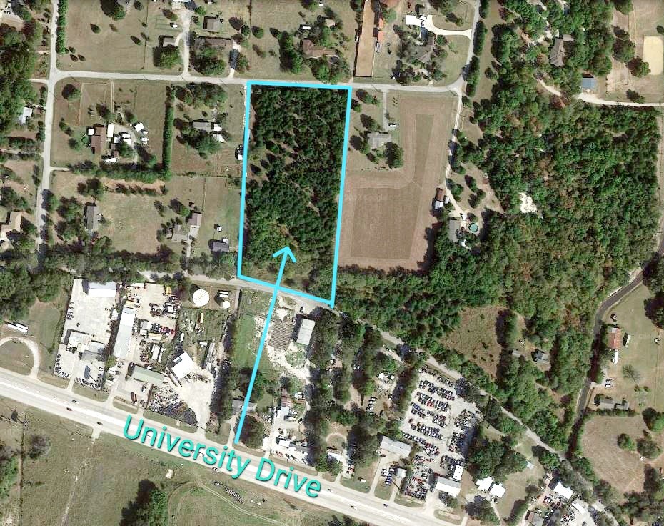 Aerial view of a wooded parcel outlined beside University Drive.