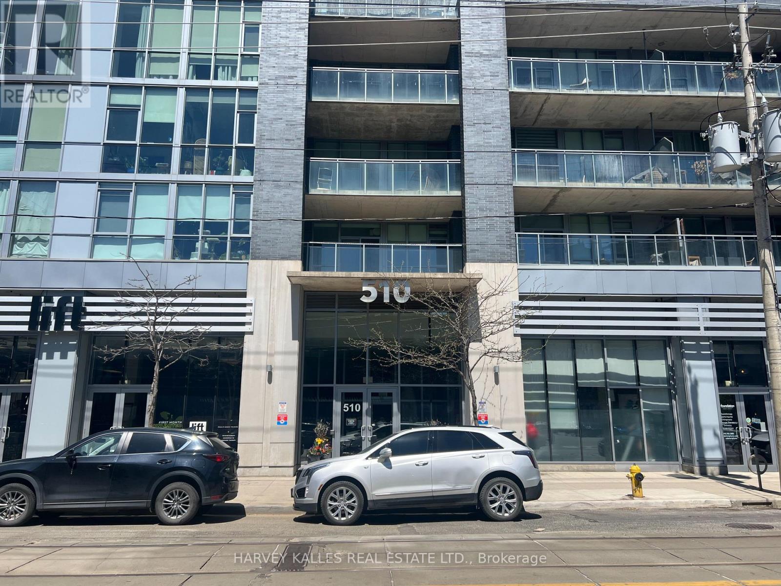 Modern condominium building at 510, with glass balconies and a street-level entrance.
