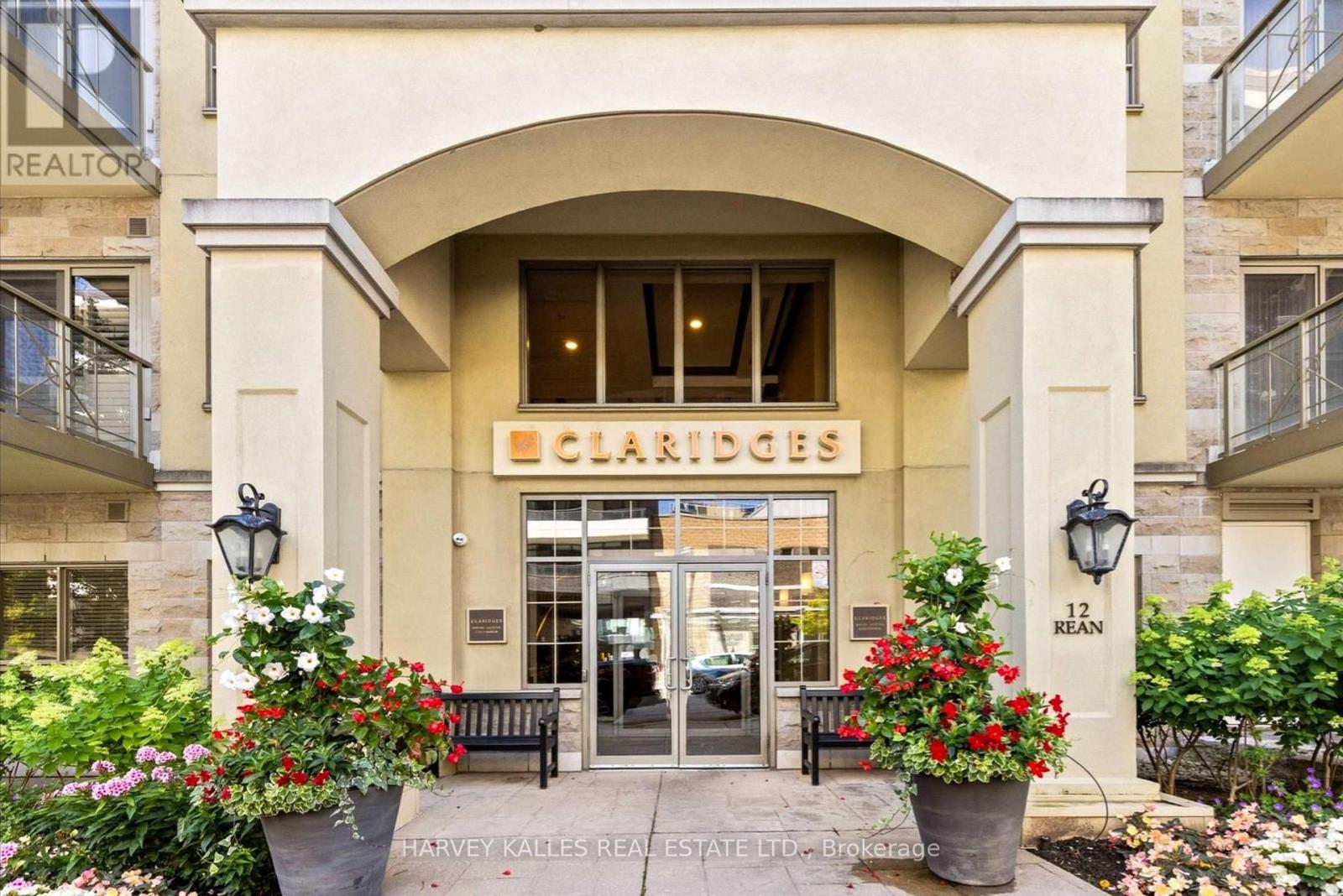 Claridges condominium entrance with an arched portico and flower-filled planters.