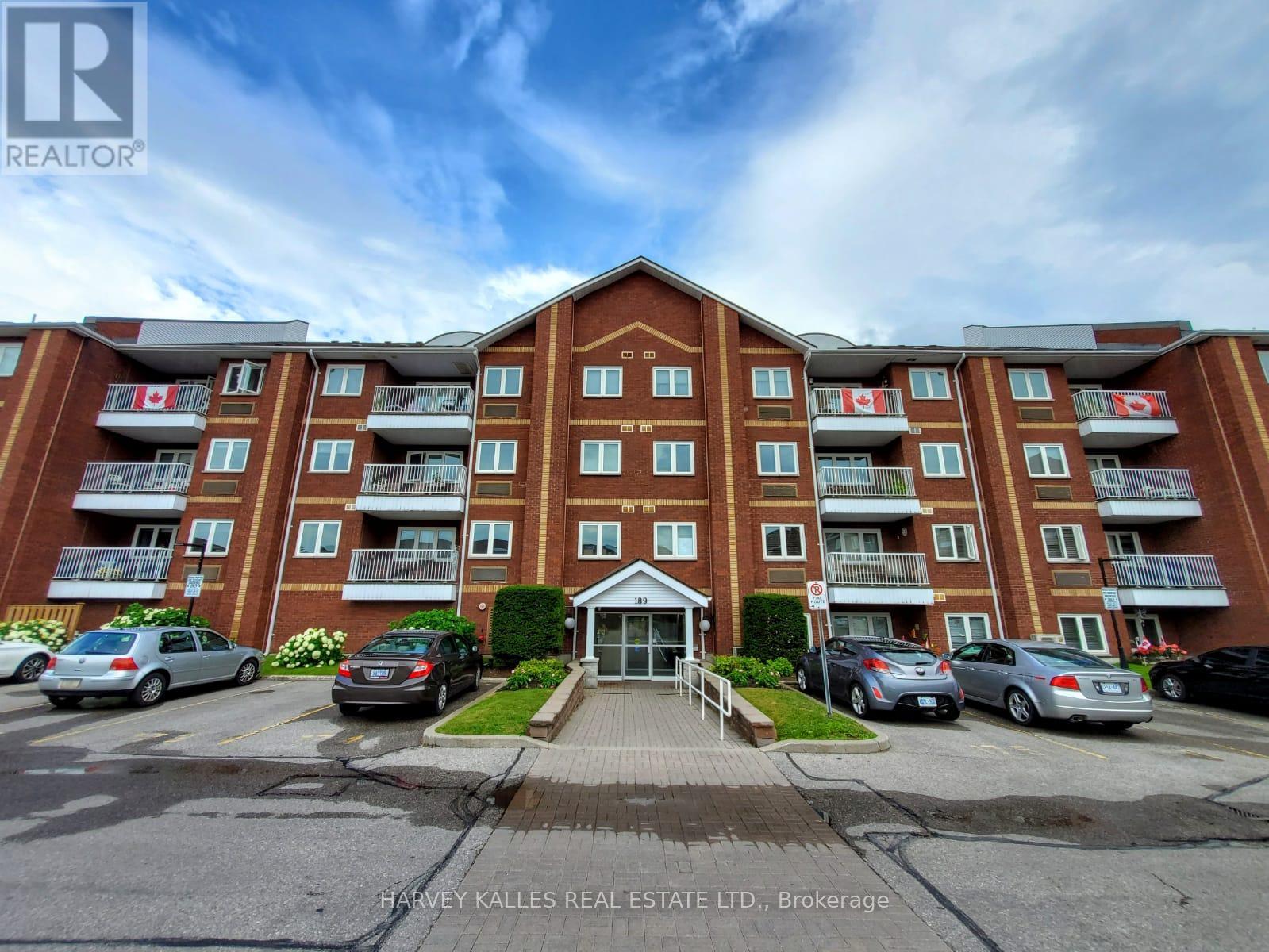 Red-brick apartment building with Canadian flags on balconies and a central entrance marked 189.