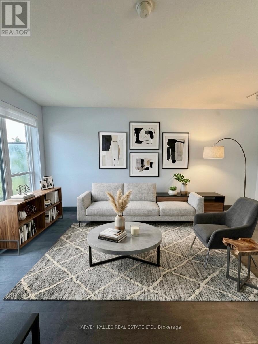 Staged living room with a light gray sofa, abstract wall art, and a large patterned rug.