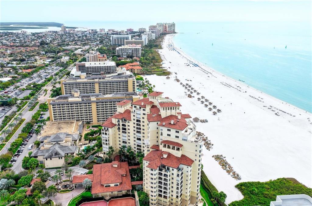 Beachfront condominium towers beside Marco Island’s white-sand beach and turquoise Gulf waters.