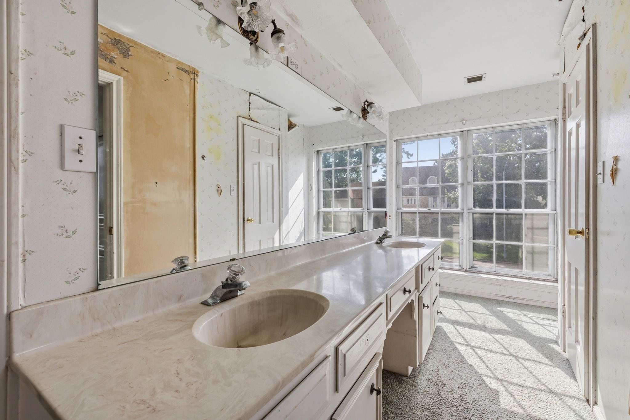 Bathroom with a long two-sink vanity and large grid windows.