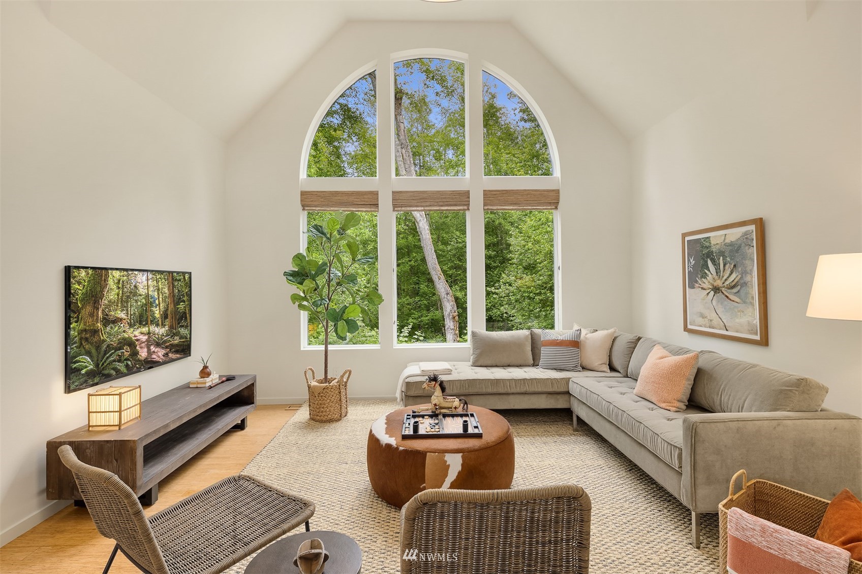 Living room with a vaulted ceiling, arched windows, and a sectional sofa.