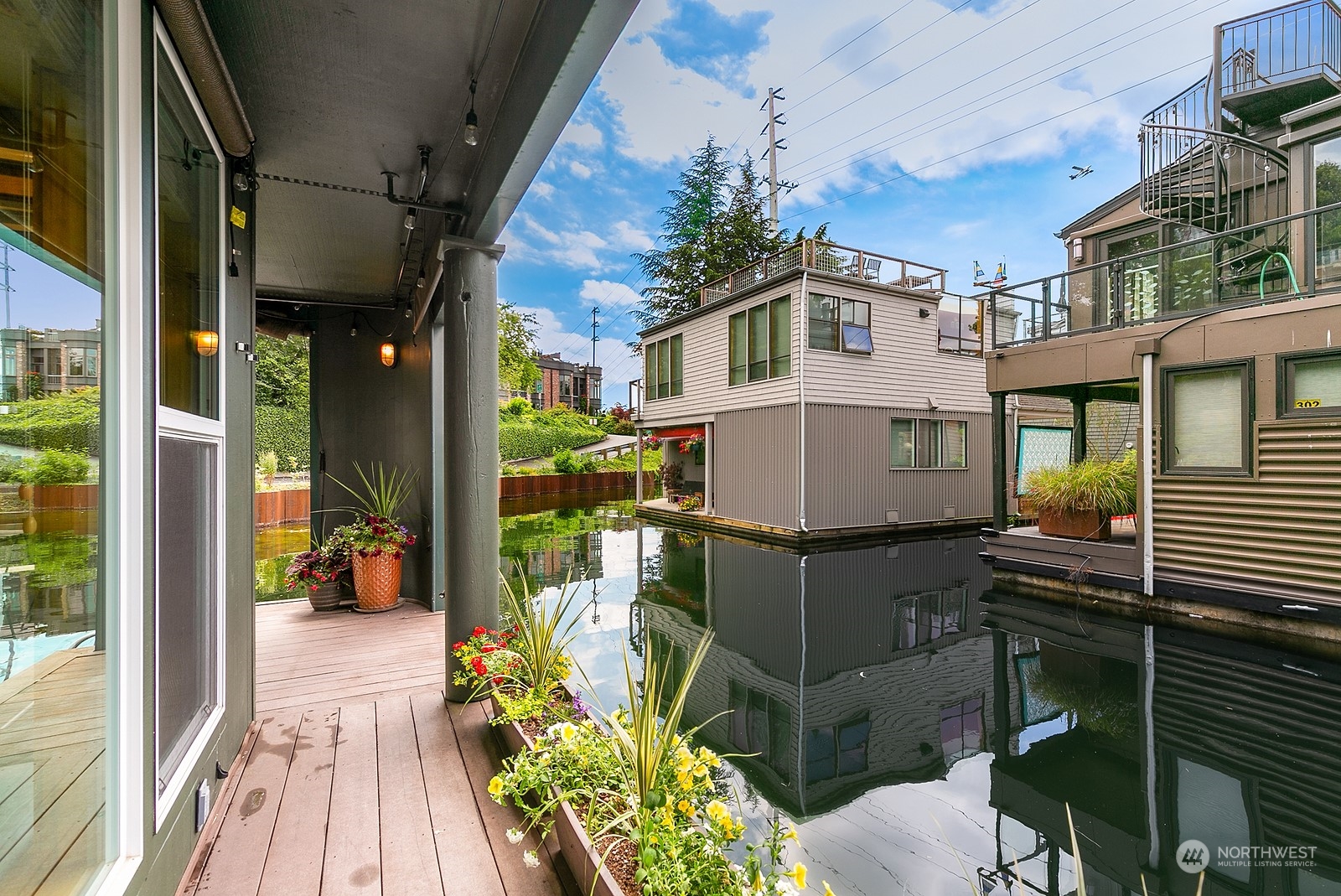 Deck overlooking a calm waterway and neighboring floating homes.
