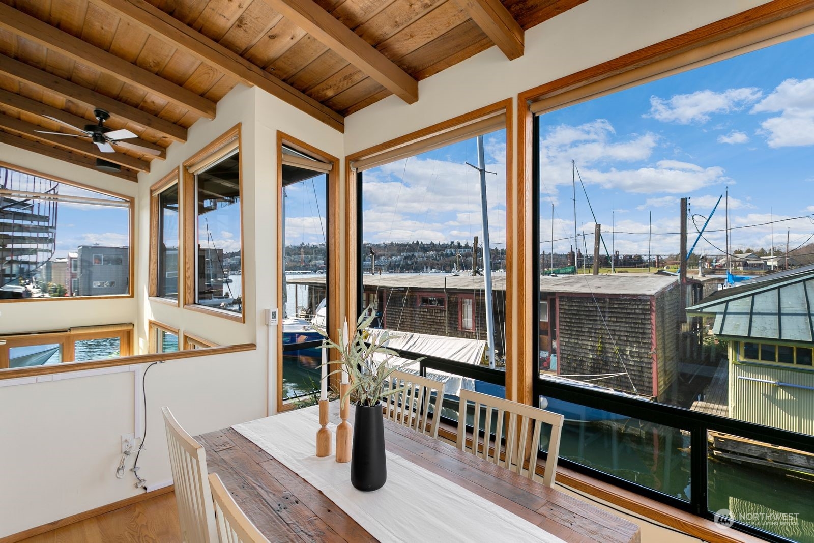 Dining area with a timber ceiling and large windows overlooking boats and marina docks.
