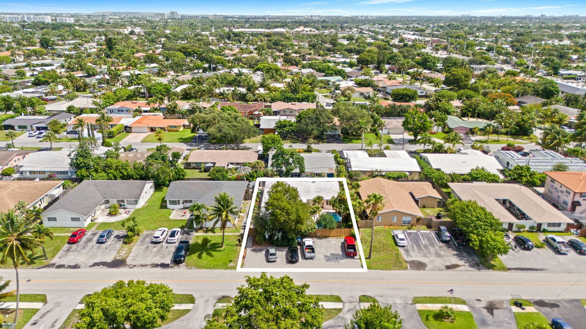 Aerial view of the outlined home and lot, with a backyard pool amid a leafy residential neighborhood.