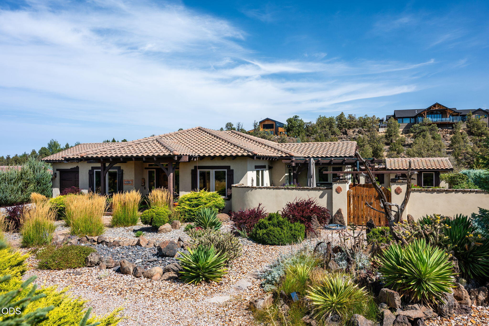 Single-story stucco home with a tile roof, walled courtyard, and drought-tolerant landscaping.