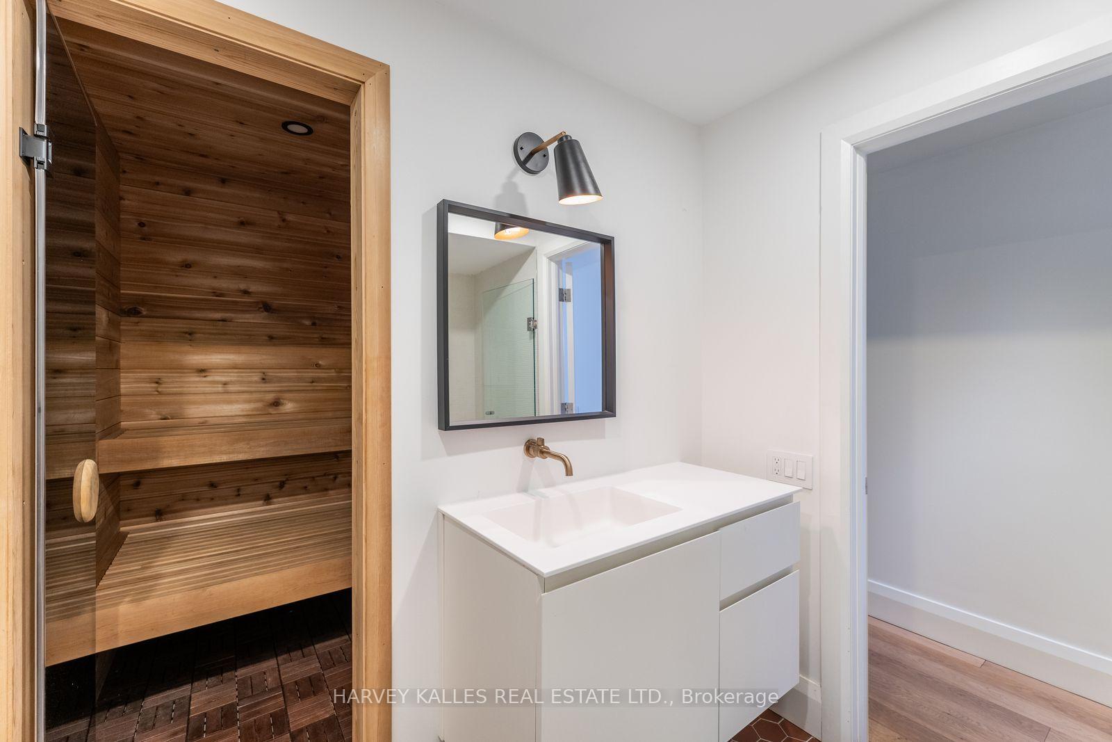 Bathroom vanity beside a cedar-lined sauna.