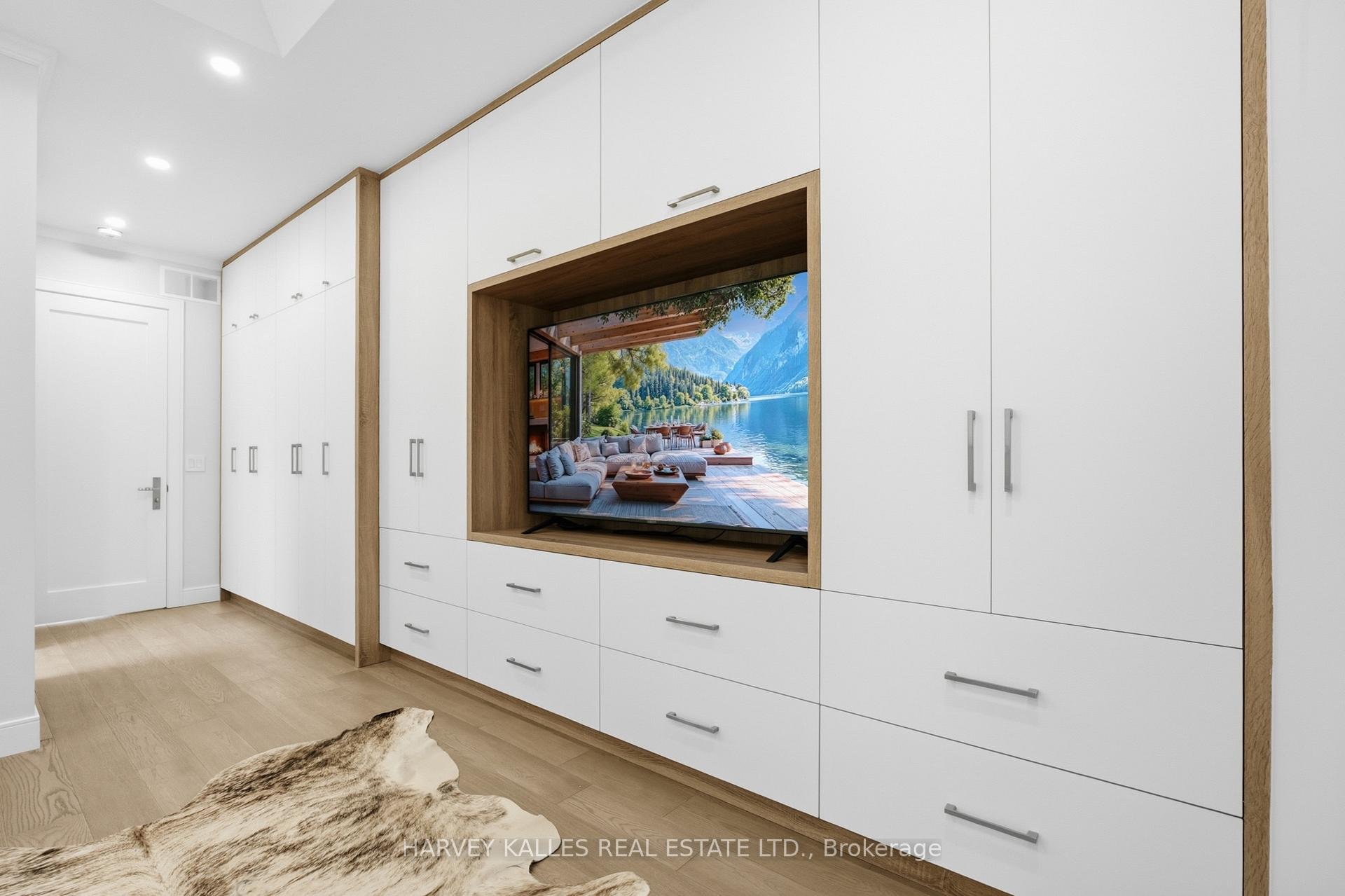Dressing room with white built-in cabinets, a wood-framed TV niche, and a hide rug.