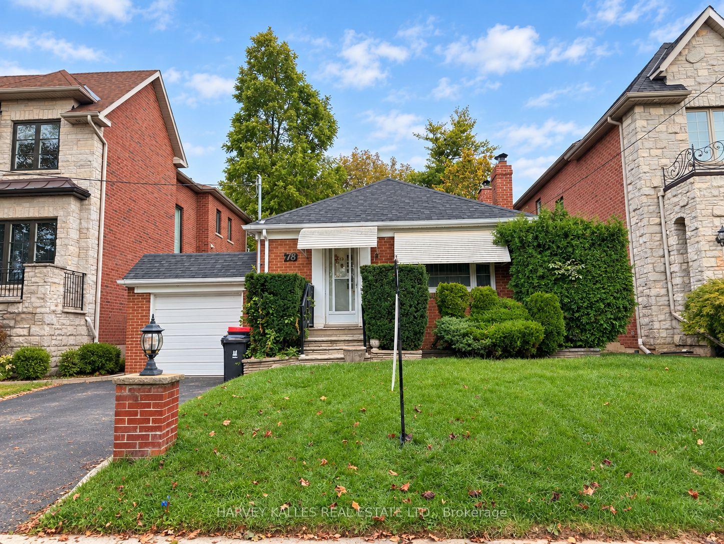 Red-brick Toronto home with an attached garage, white awnings, and a broad front lawn.