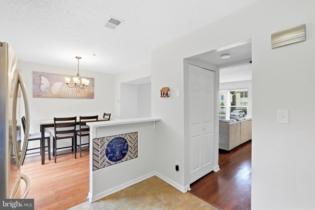 Dining area with a breakfast bar, dark wood chairs, and a view into the living room.
