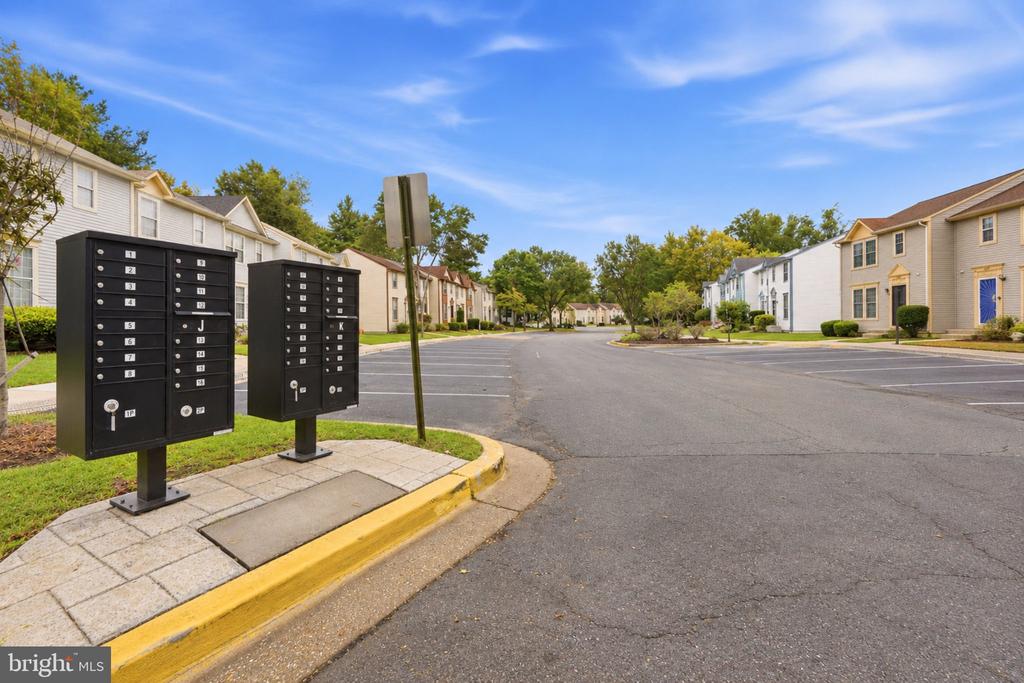 Residential community street with attached homes and black mailboxes in the foreground.