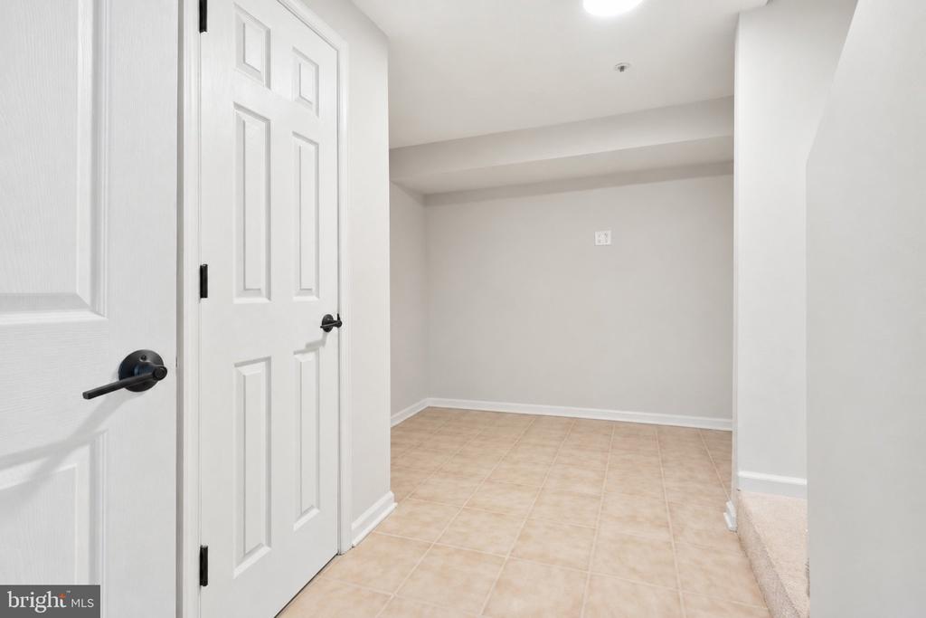 Empty room with beige tile flooring and white paneled doors.