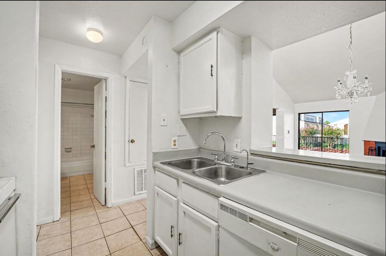 Kitchen with a double-basin sink and pass-through to a living area with a balcony.