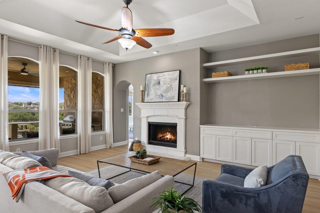 Living room with a white fireplace, built-in shelves, arched windows, and seating around a coffee table.