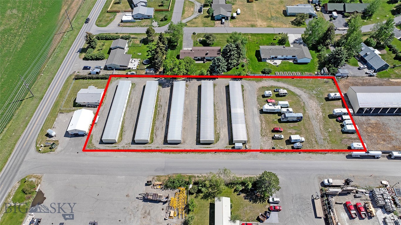 Aerial view of a storage facility outlined in red, with covered bays and parked RVs.