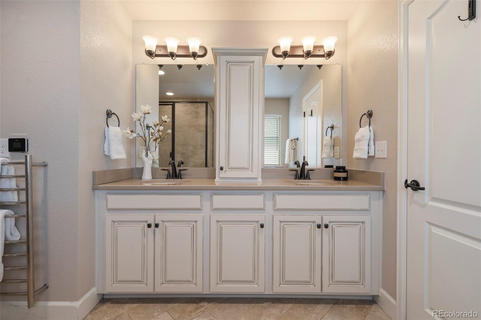 Bathroom with a white double-sink vanity, framed mirrors, and a glass-enclosed shower.