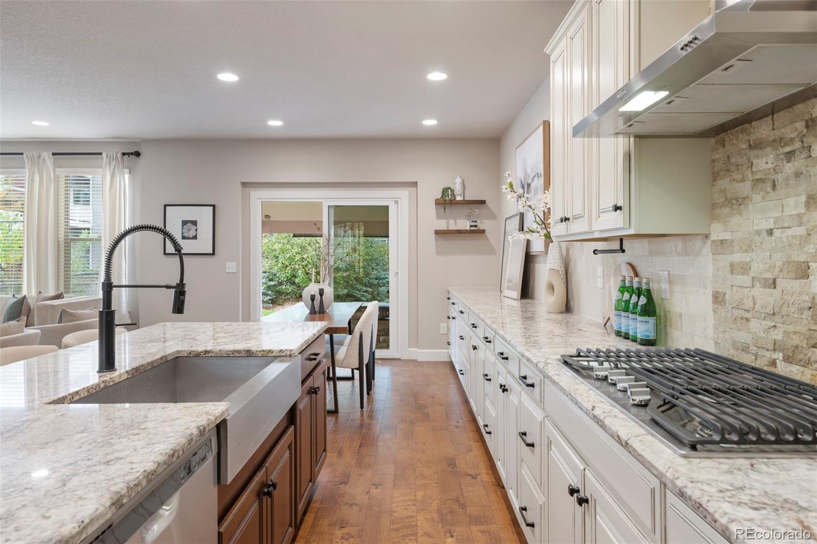 Kitchen with white cabinetry, stone counters, a large island, and a gas cooktop.