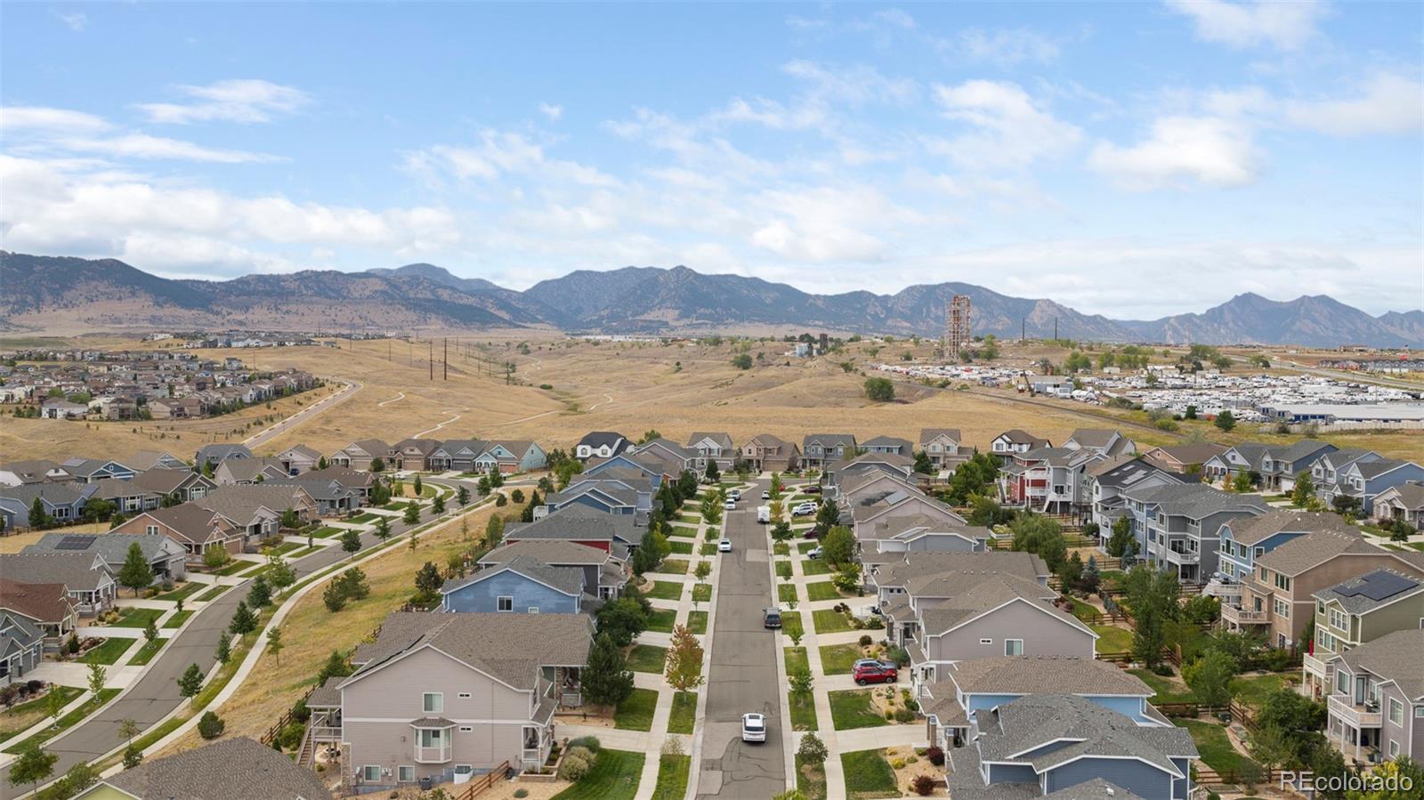 Aerial neighborhood view with homes in the foreground and mountains on the horizon.