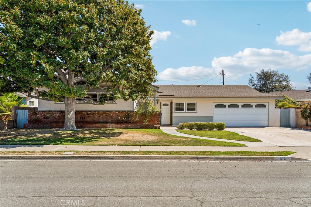 Single-story Anaheim home with an attached two-car garage and a large shade tree in front.
