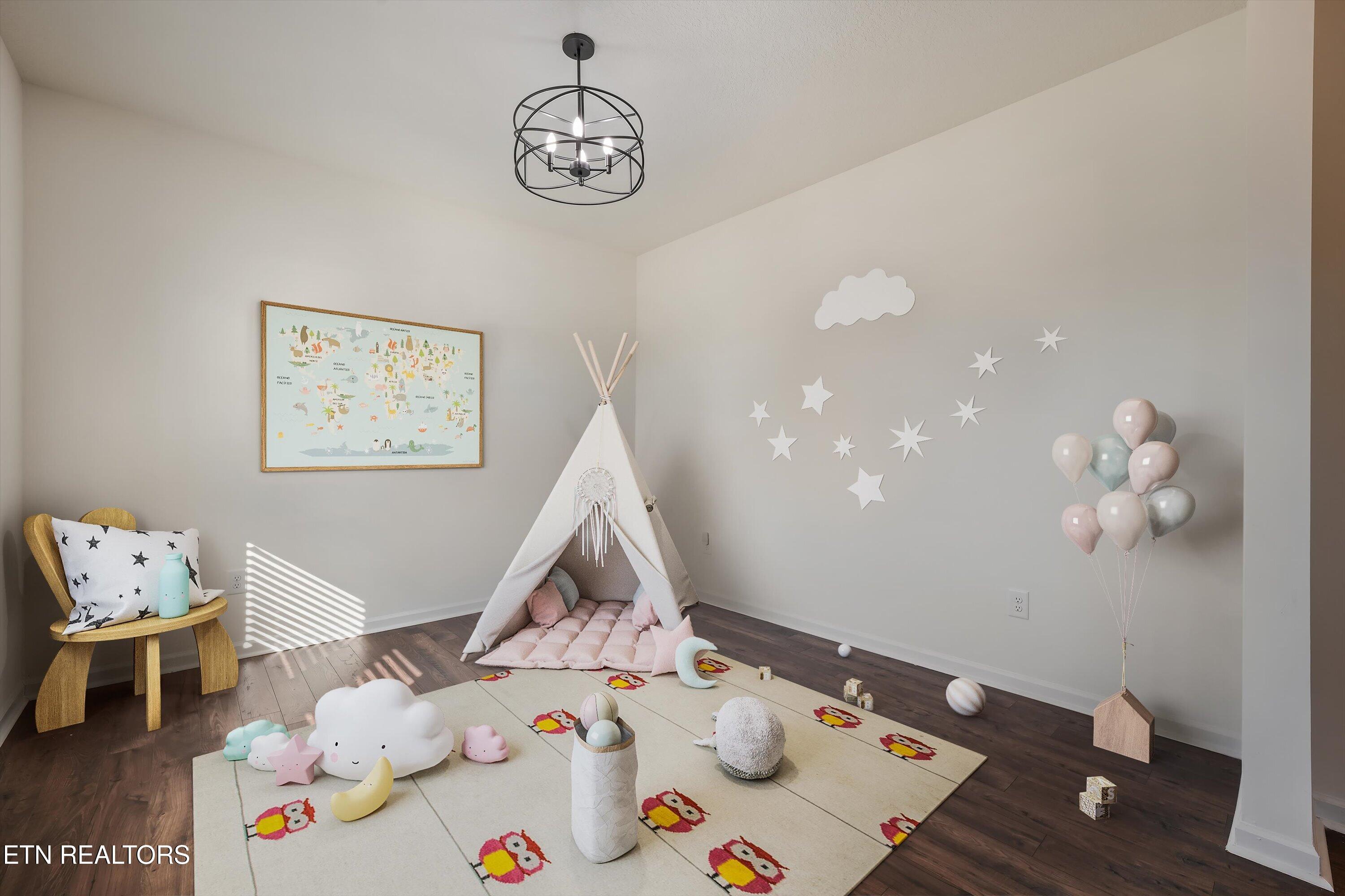Nursery with a white teepee tent, pink cushion, star decorations, and an owl-patterned rug.