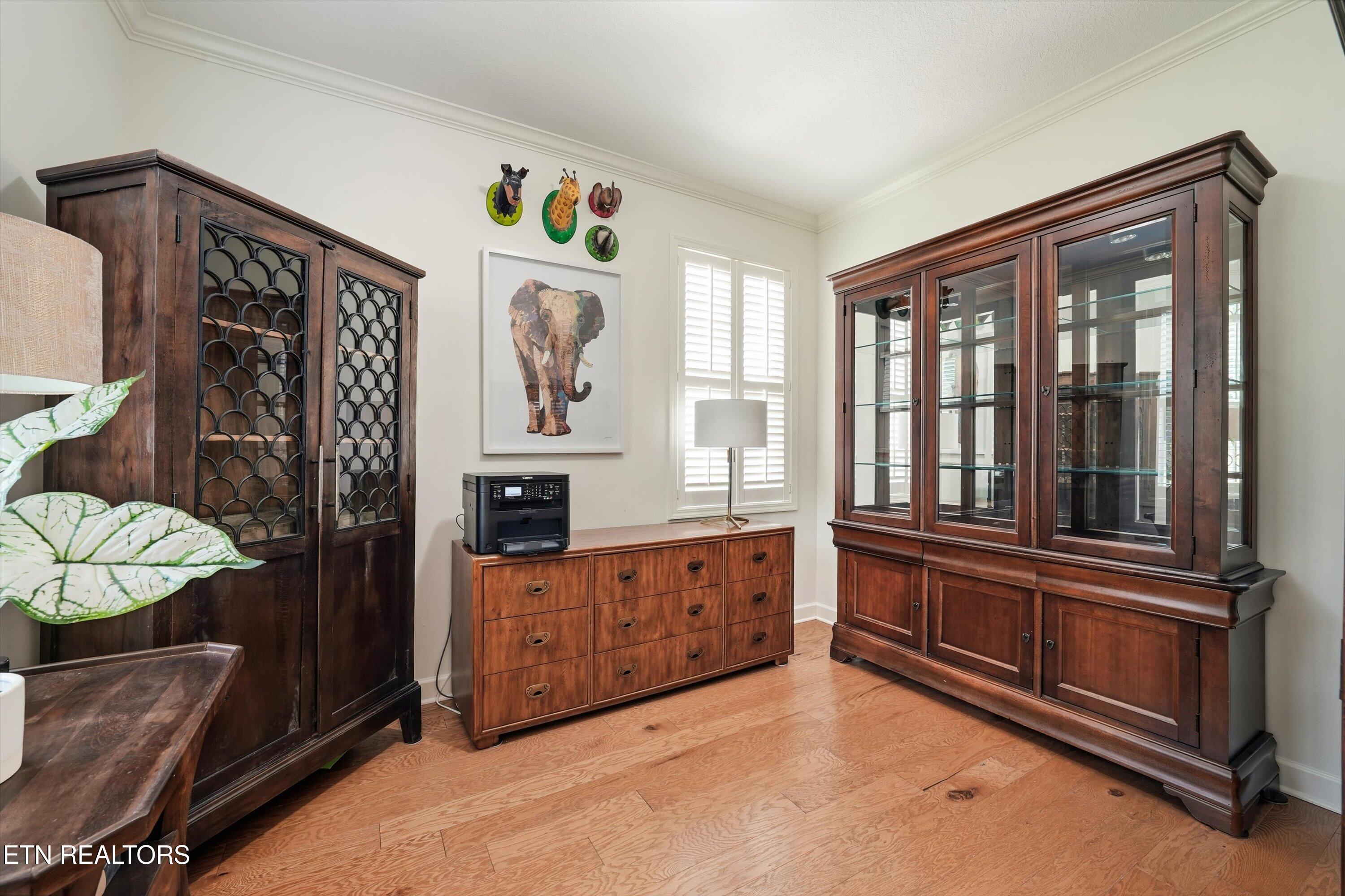 Dining room with dark wood display cabinets, a matching chest, and hardwood floors.