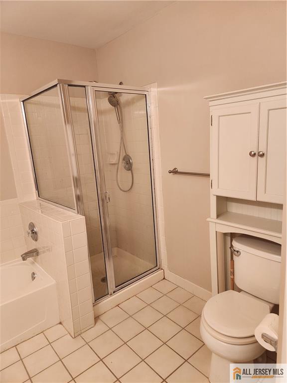 Bathroom with a glass-enclosed shower, bathtub, and built-in white cabinetry.