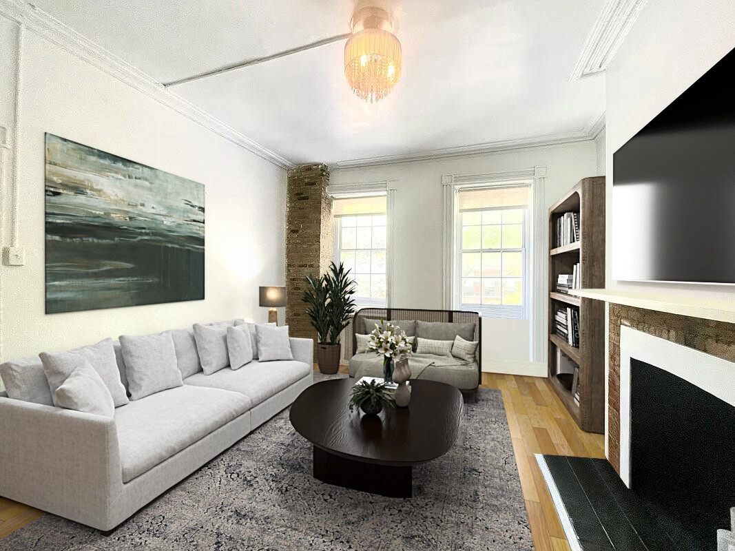 Living room with a white sofa, brick fireplace, hardwood floors, and two tall windows.