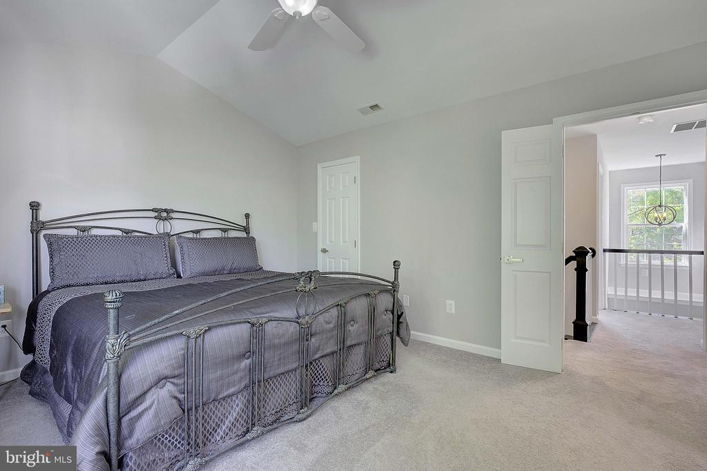 Bedroom with a large metal four-poster bed and an open doorway to a bright landing.