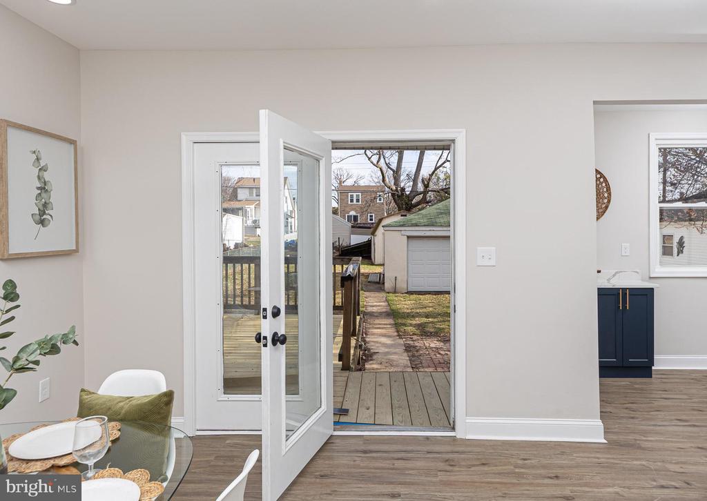 Interior dining area with an open back door leading to a deck and backyard.