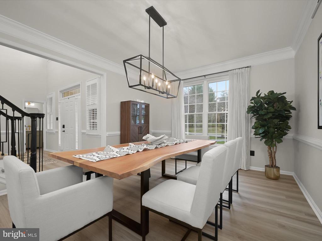 Dining room with a live-edge wood table, white chairs, and a black geometric chandelier.