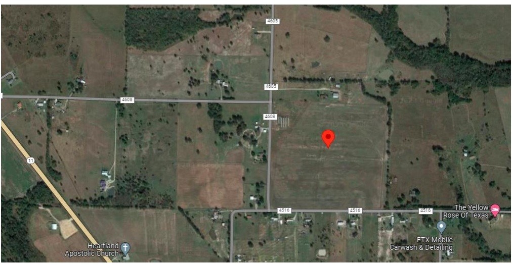 Aerial map with a red location pin among rural fields, roads, and nearby landmarks.