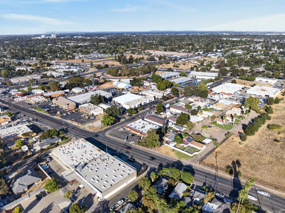 Aerial view of Sacramento blocks with commercial buildings, tree-lined neighborhoods, and intersecting roads.