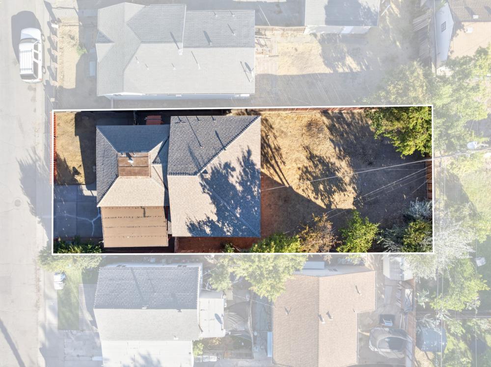 Aerial view of a house and cleared yard, with the property outlined in white.