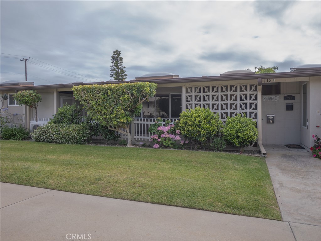 Single-story home with a decorative breeze-block screen, landscaped front lawn, and address 1781.