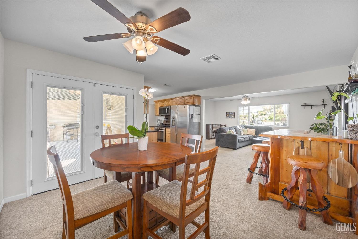 Dining area with a round wooden table, opening to a kitchen and living room.