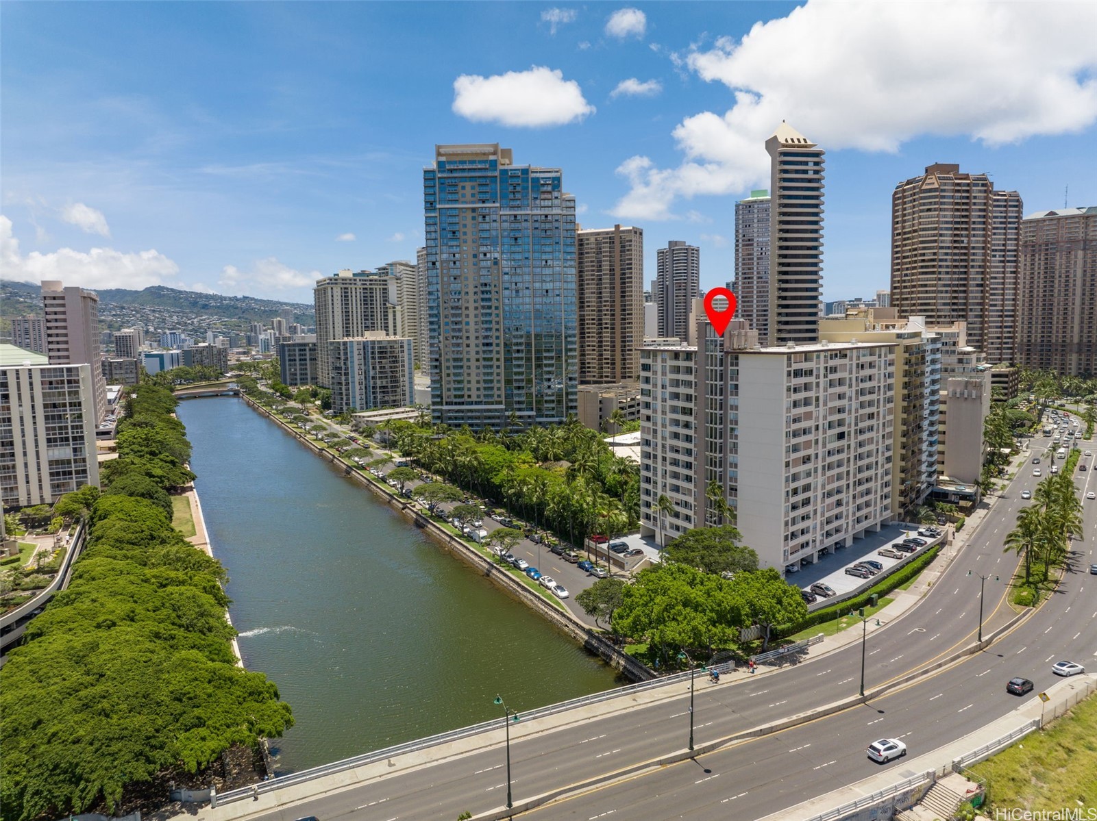 Aerial view of the marked Honolulu condominium beside a canal and highway.