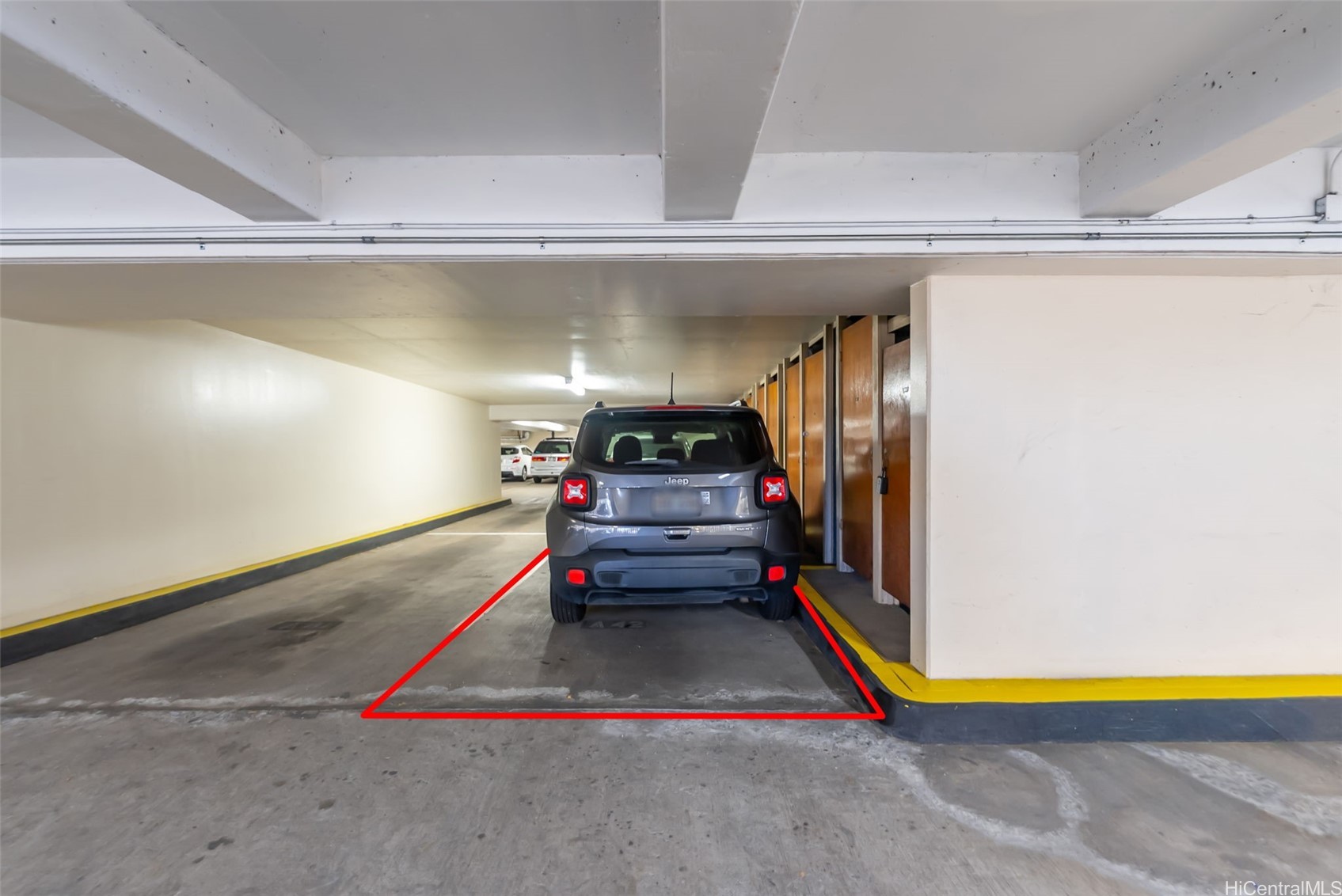 Condominium garage parking stall outlined in red, with a gray Jeep and storage lockers.