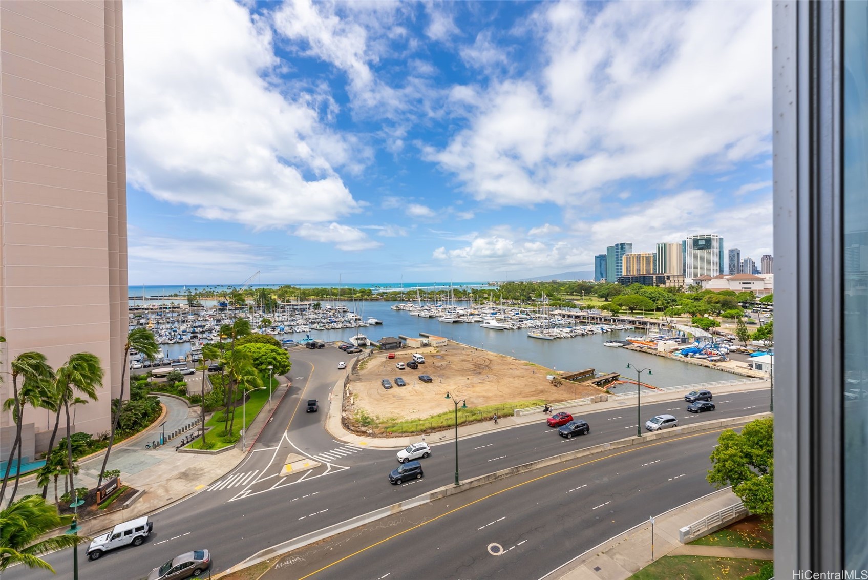 Marina and sailboats, ocean, and Honolulu skyline viewed from a high-rise window.