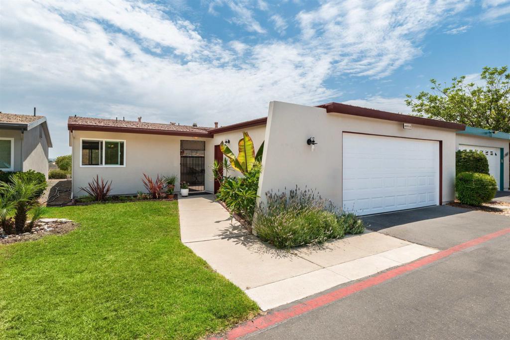 Single-story home with attached garage, front lawn, walkway, and landscaped entry.