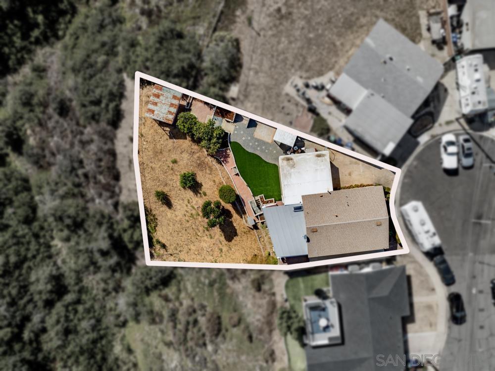 Aerial view of a home and backyard within a white-outlined lot.