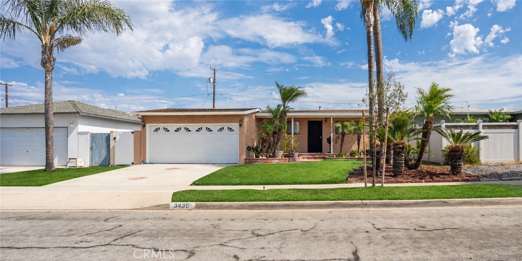 Single-story home with a two-car garage, wide driveway, palm trees, and 3435 on the curb.