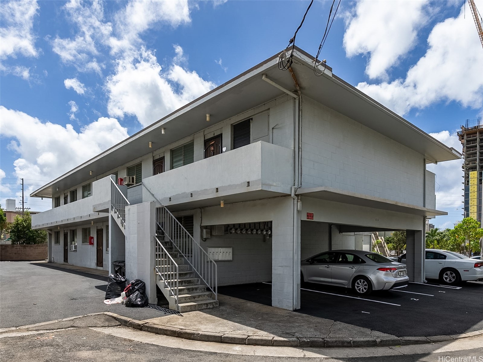 Two-story apartment building with an exterior staircase and covered parking at 823 Waiaka Place.